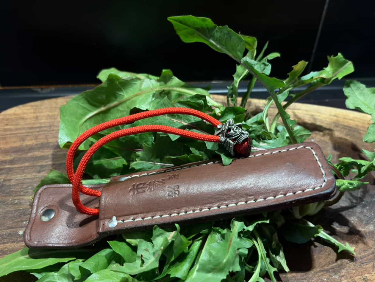 Ichizo Honpo leather knife case with red cord on fresh herbs