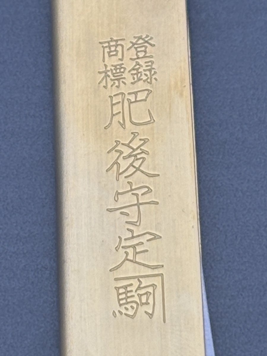 真鍮の柄に縦書きで刻まれた「肥後守定駒」の文字